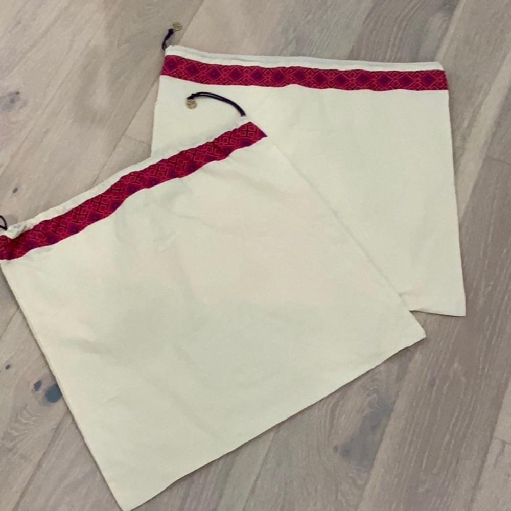 Cream color Tory Burch purse dust covers.